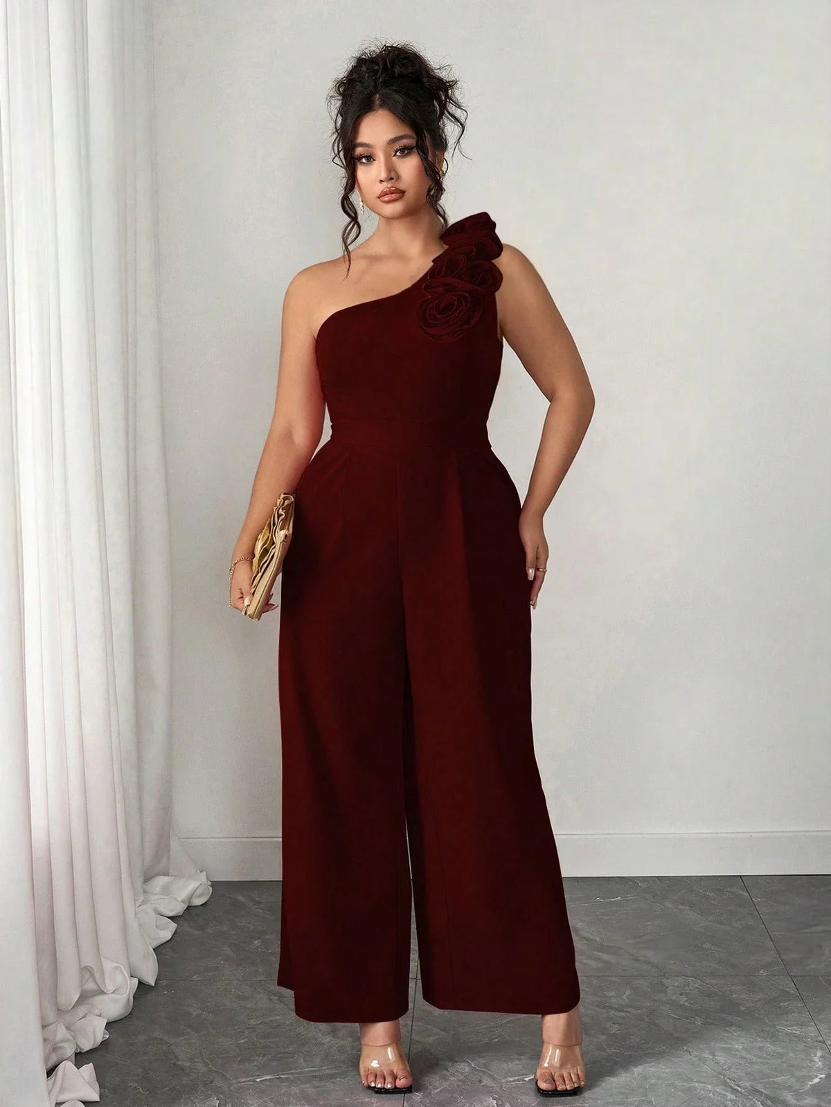 Macacão Plus Size Pantalona Assimétrico com Flor no Ombro